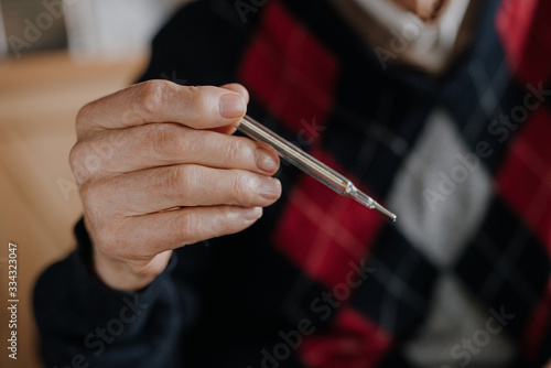 Old Man Holding Thermometer in hand Covid-19