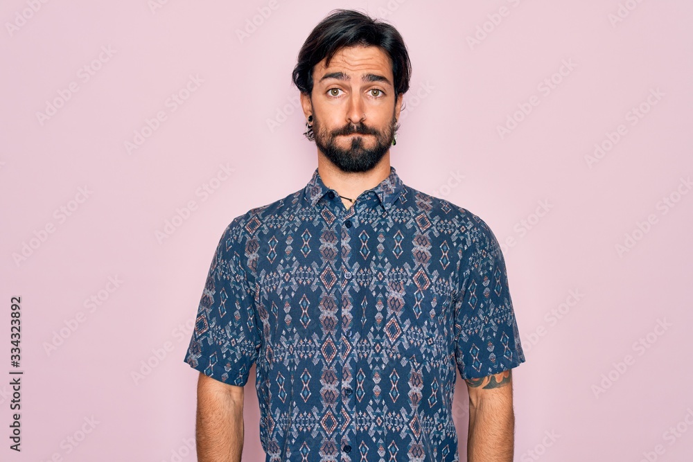Young handsome hispanic bohemian man wearing hippie style over pink background puffing cheeks with funny face. Mouth inflated with air, crazy expression. Young handsome hispanic bohemian man wearing hippie style over pink background puffing cheeks with funny face. Mouth inflated with air, crazy expression.