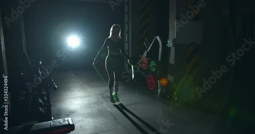 girl Athlete exercising on jumping rope in gym hard working