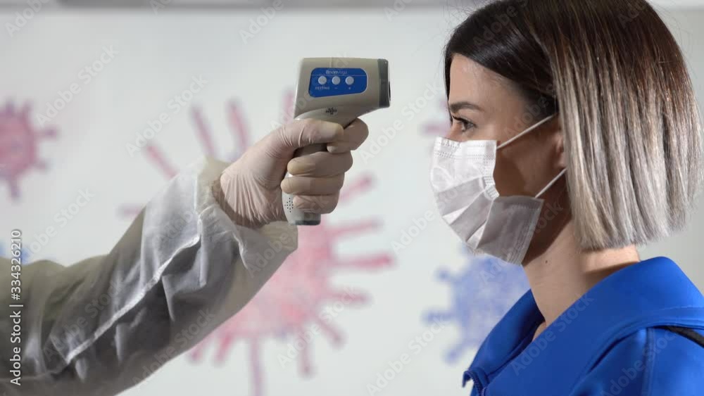 Taking woman 's temperature with thermometer to find infected by coronavirus, Covid-19. Close up shot. Coronavirus test on people Taking woman 's temperature with thermometer to find infected by coronavirus, Covid-19. Close up shot. Coronavirus test on people