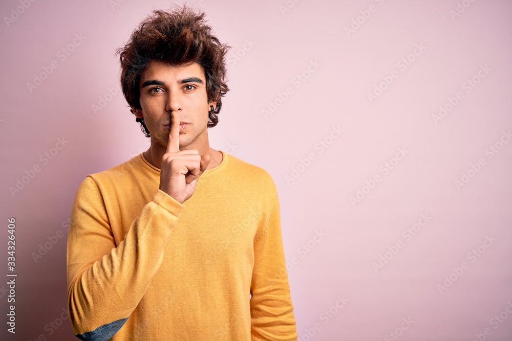 Young handsome man wearing yellow casual t-shirt standing over isolated pink background asking to be quiet with finger on lips. Silence and secret concept. Young handsome man wearing yellow casual t-shirt standing over isolated pink background asking to be quiet with finger on lips. Silence and secret concept.