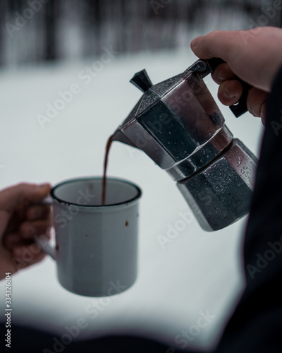 Man pouring coffee in a mug - Cold winter scenery