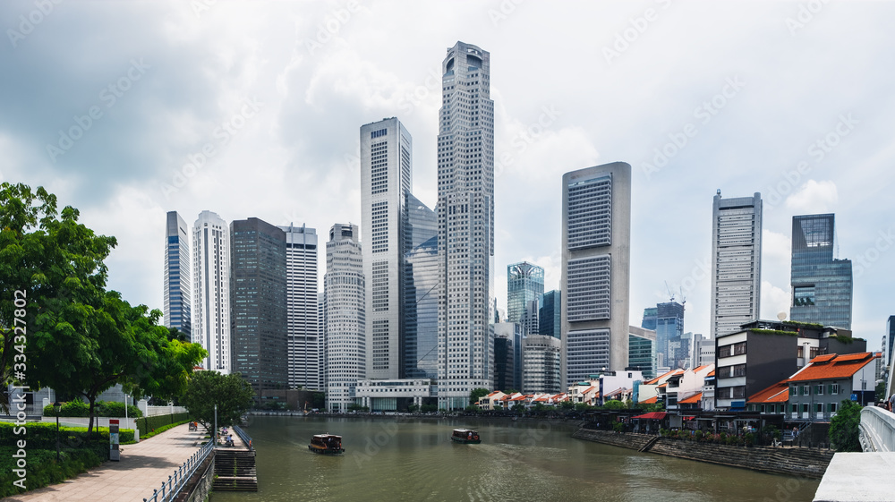 Fototapeta premium Modern skyline of Singapore city, urban asian cityscape with skyscraper buildings and river with boat in commercial business district