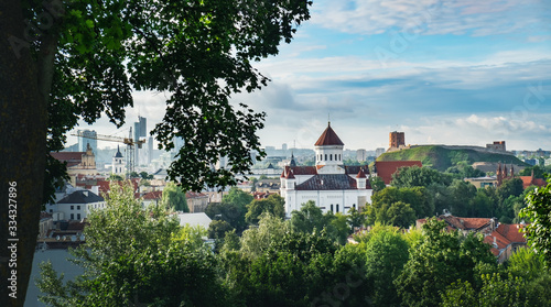 Prechistensky Cathedral, Orthodox Church in Old Town of Vilnius, Lithuania. Panoramic summer cityscape urban view with Gediminas Castle Tower, blue cloudy sky and green trees