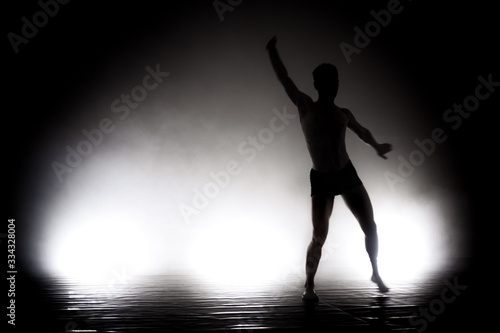 modern ballet dancer performing. motion blur and smoke