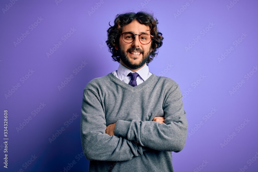 Handsome businessman with beard wearing tie and glasses standing over purple background happy face smiling with crossed arms looking at the camera. Positive person. Handsome businessman with beard wearing tie and glasses standing over purple background happy face smiling with crossed arms looking at the camera. Positive person.
