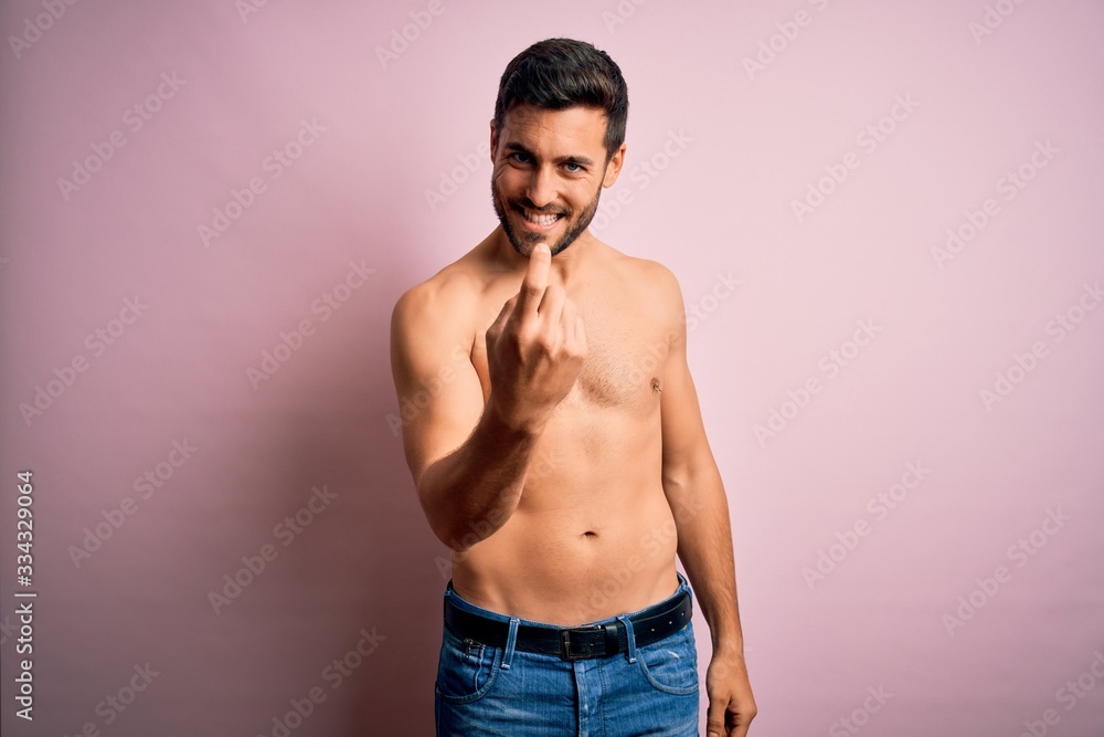 Young handsome strong man with beard shirtless standing over isolated pink background Beckoning come here gesture with hand inviting welcoming happy and smiling