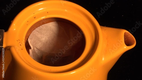 Pouring hot water into a teapot with teabag 4K photo