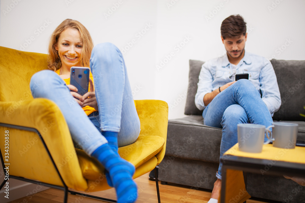 couple at home looking at their smart phones