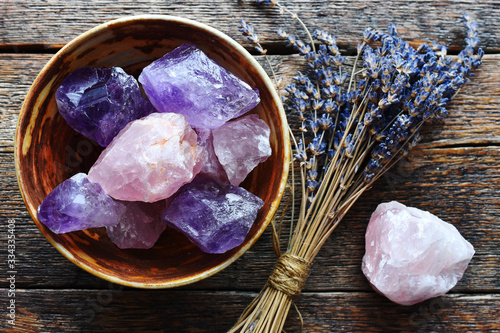 Obraz na plátně A table top image of a pottery bowl with large rose quartz and amethyst crystal with dried lavender flowers