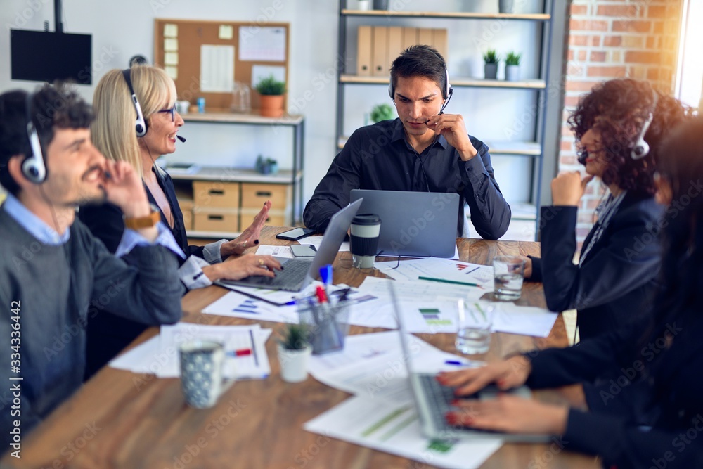 Group of call center workers smiling happy and confident. Working together with smile on face using headset at the office. Group of call center workers smiling happy and confident. Working together with smile on face using headset at the office.