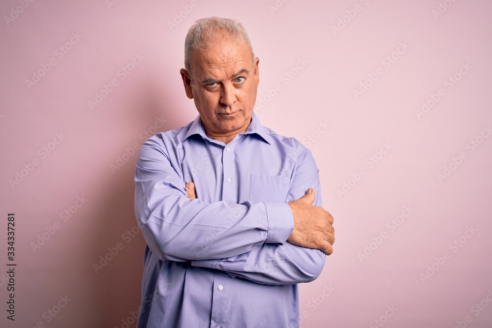 Middle age handsome hoary man wearing casual shirt standing over pink background skeptic and nervous, disapproving expression on face with crossed arms. Negative person. Middle age handsome hoary man wearing casual shirt standing over pink background skeptic and nervous, disapproving expression on face with crossed arms. Negative person.