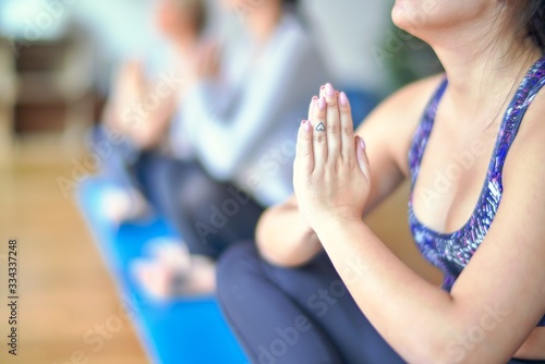 Young beautiful group of sportswomen practicing yoga at gym