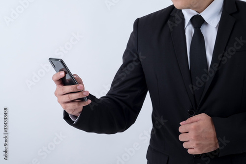Business and technology. Confident young man in suit and tie using smart phone, isolated on white background