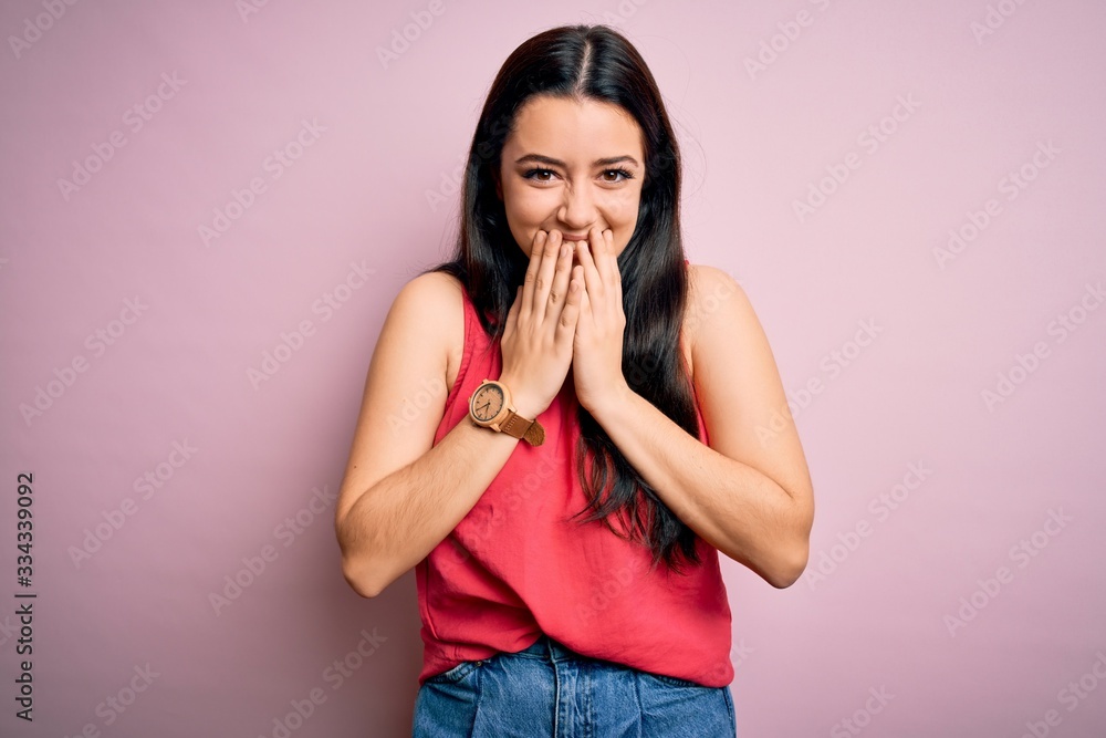 Young brunette woman wearing casual summer shirt over pink isolated background laughing and embarrassed giggle covering mouth with hands, gossip and scandal concept Young brunette woman wearing casual summer shirt over pink isolated background laughing and embarrassed giggle covering mouth with hands, gossip and scandal concept