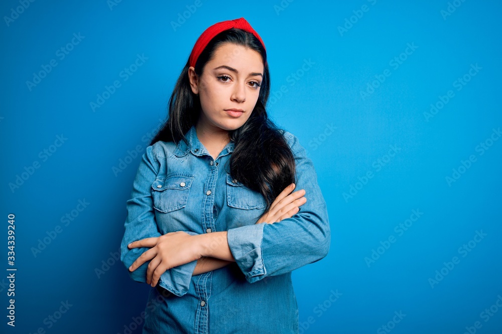 Young brunette woman wearing casual denim shirt over blue isolated background looking sleepy and tired, exhausted for fatigue and hangover, lazy eyes in the morning. Young brunette woman wearing casual denim shirt over blue isolated background looking sleepy and tired, exhausted for fatigue and hangover, lazy eyes in the morning.