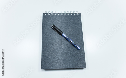 Concept of notepad phone pen. The photo was taken on white background and studio. Close up.