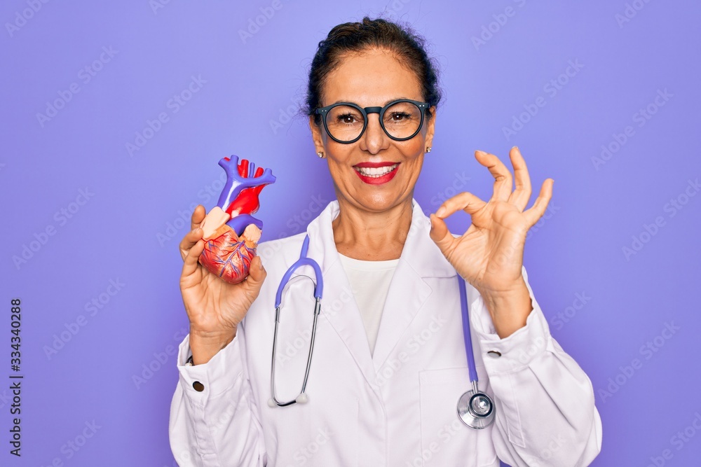 Φωτογραφία Middle age senior cardiologist doctor woman holding professional cardiology hear