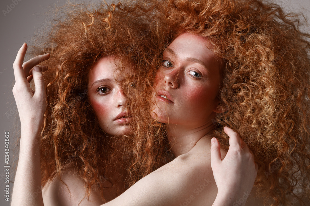 Fototapeta premium Fashion portrait of two young beautiful women with red hairs. Creative hairstyle.