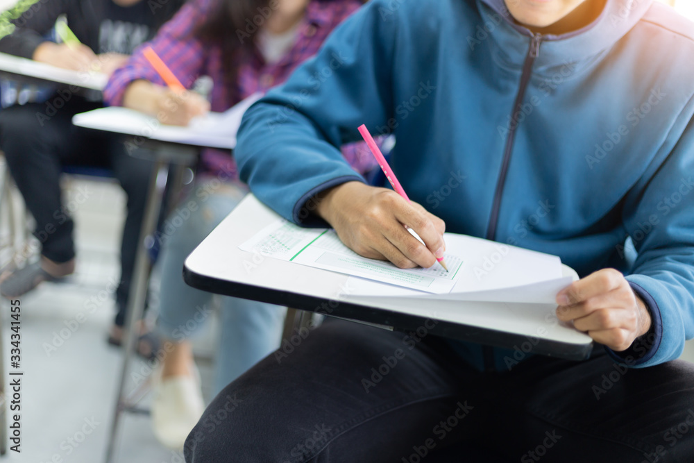soft focus.high school,university student study.hands writing paper answer sheet.sitting lecture chair taking final exam attending in examination classroom.concept scholarship for education abroad soft focus.high school,university student study.hands writing paper answer sheet.sitting lecture chair taking final exam attending in examination classroom.concept scholarship for education abroad