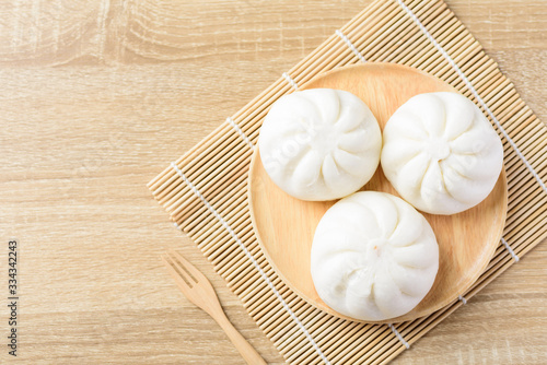 Steamed buns stuffed with minced pork on wooden plate and fork ready to eating, Asian food