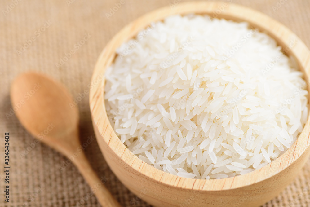 Organic Thai Jasmine rice grain in a bowl and spoon preparing for cooked Organic Thai Jasmine rice grain in a bowl and spoon preparing for cooked