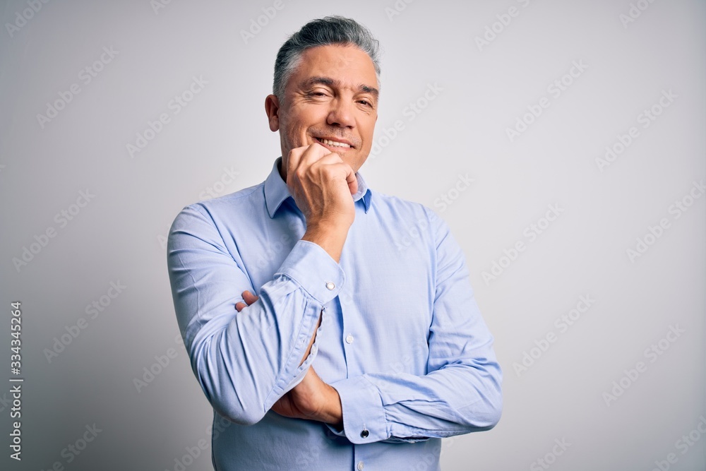 Middle age handsome grey-haired business man wearing elegant shirt over white background looking confident at the camera with smile with crossed arms and hand raised on chin. Thinking positive. Middle age handsome grey-haired business man wearing elegant shirt over white background looking confident at the camera with smile with crossed arms and hand raised on chin. Thinking positive.