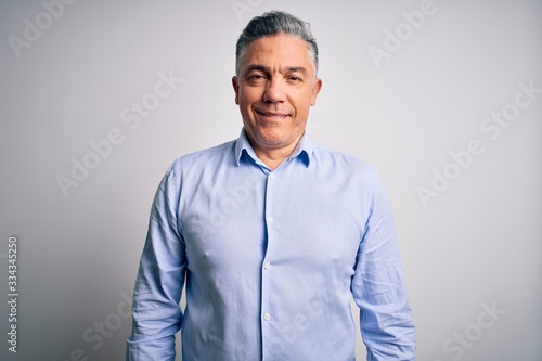 Middle age handsome grey-haired business man wearing elegant shirt over white background with a happy and cool smile on face. Lucky person.