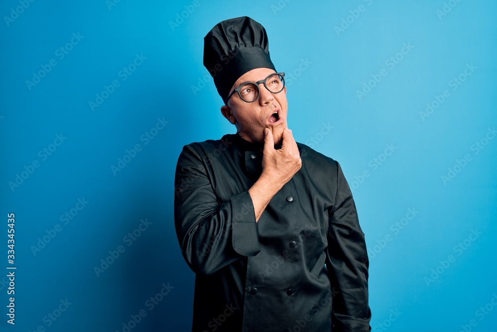 Middle age handsome grey-haired chef man wearing cooker uniform and hat Thinking worried about a question, concerned and nervous with hand on chin Middle age handsome grey-haired chef man wearing cooker uniform and hat Thinking worried about a question, concerned and nervous with hand on chin