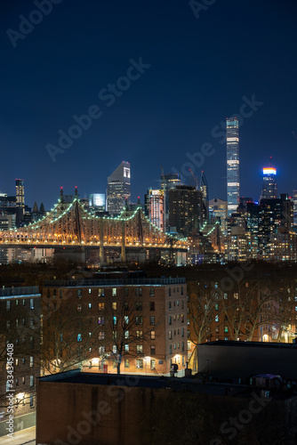 Panoramic Cityscape View of New York City at night with illuminated skyscrapers and bridges inside urban city center