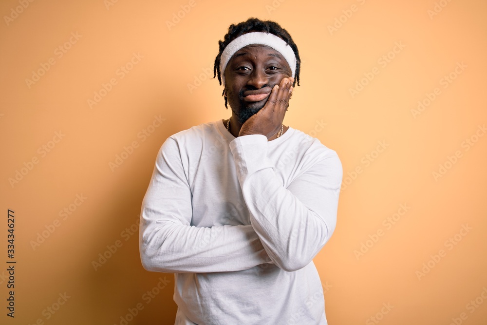 Young african american man doing sport wearing sportswer over isolated yellow background thinking looking tired and bored with depression problems with crossed arms. Young african american man doing sport wearing sportswer over isolated yellow background thinking looking tired and bored with depression problems with crossed arms.