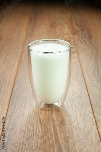 Full glass of milk for a breakfast on a wooden table splashes of milk.