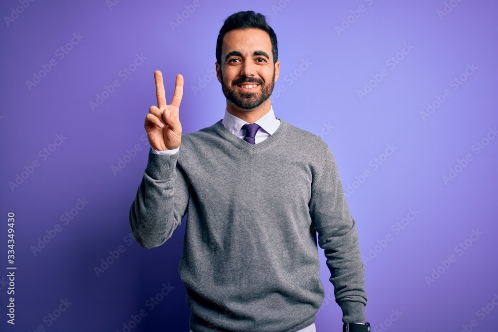 Handsome businessman with beard wearing casual tie standing over purple background showing and pointing up with fingers number two while smiling confident and happy. Handsome businessman with beard wearing casual tie standing over purple background showing and pointing up with fingers number two while smiling confident and happy.