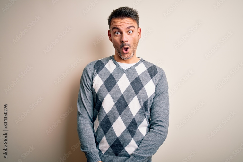 Young handsome man wearing casual sweater standing over isolated white background afraid and shocked with surprise expression, fear and excited face. Young handsome man wearing casual sweater standing over isolated white background afraid and shocked with surprise expression, fear and excited face.