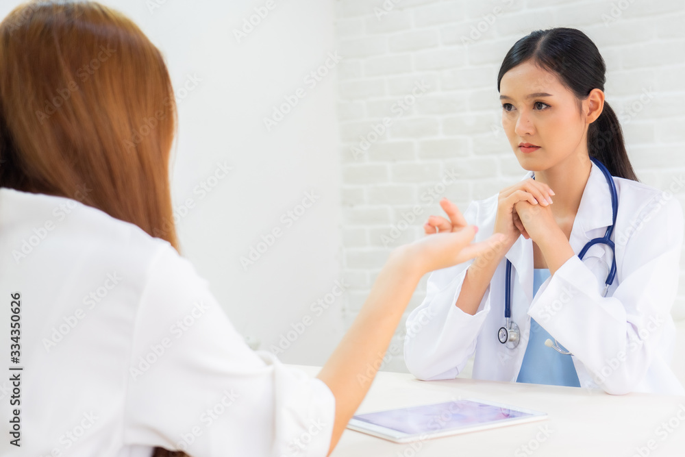 Female doctor talking to patient.Doctor and patient discussing something while sitting at the table . Medicine and health care concept. Doctor and patient Female doctor talking to patient.Doctor and patient discussing something while sitting at the table . Medicine and health care concept. Doctor and patient