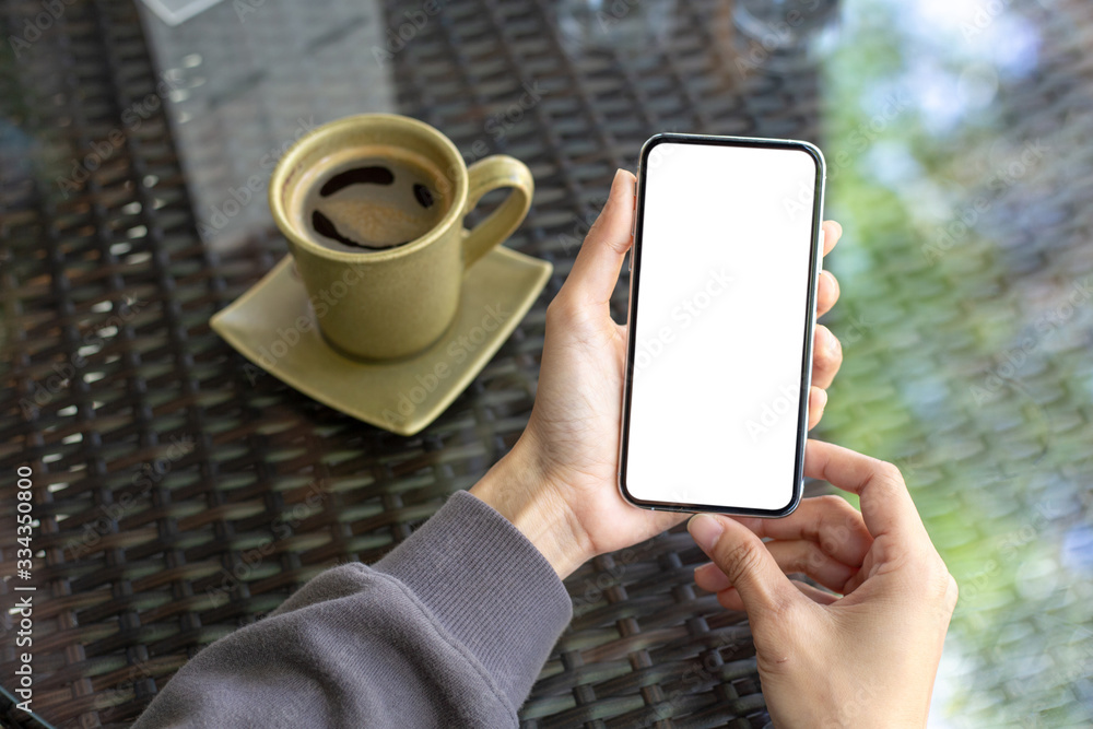 cell phone Mockup image blank white screen.woman hand holding texting using mobile on desk at coffee shop.background empty space for advertise text.people contact marketing business,technology