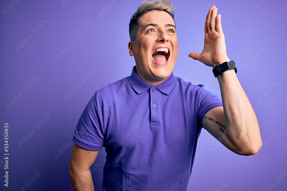 Young handsome modern man wearing casual purple t-shirt over isolated background shouting and screaming loud to side with hand on mouth. Communication concept. Young handsome modern man wearing casual purple t-shirt over isolated background shouting and screaming loud to side with hand on mouth. Communication concept.