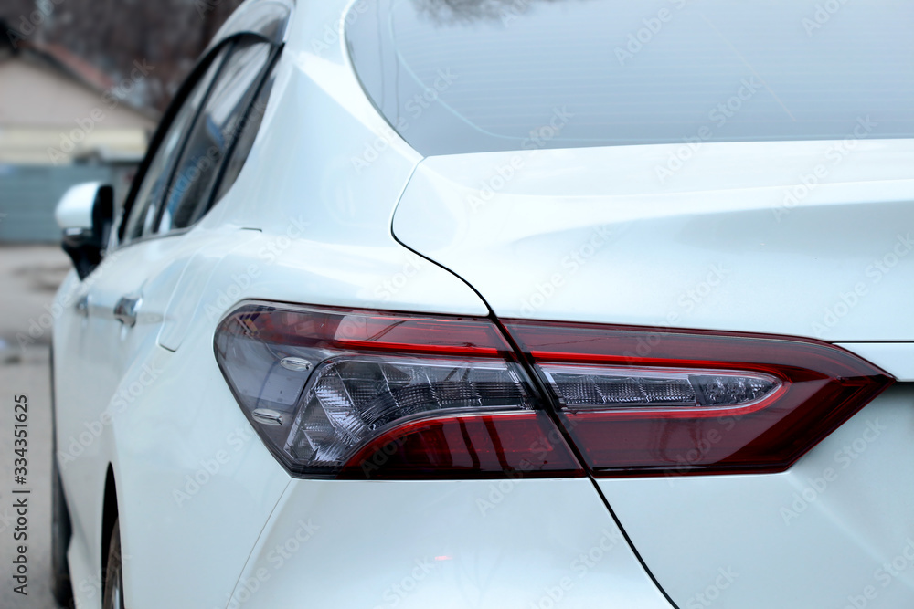 Naklejka premium Red headlight on a white car