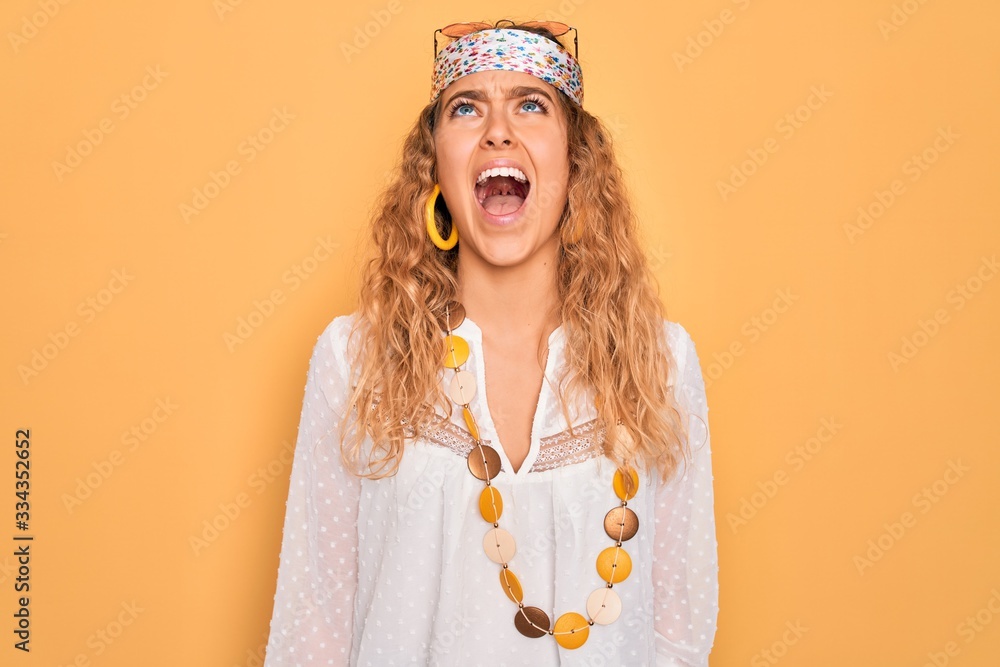 Young beautiful blonde hippie woman with blue eyes wearing sunglasses and accessories angry and mad screaming frustrated and furious, shouting with anger. Rage and aggressive concept. Young beautiful blonde hippie woman with blue eyes wearing sunglasses and accessories angry and mad screaming frustrated and furious, shouting with anger. Rage and aggressive concept.