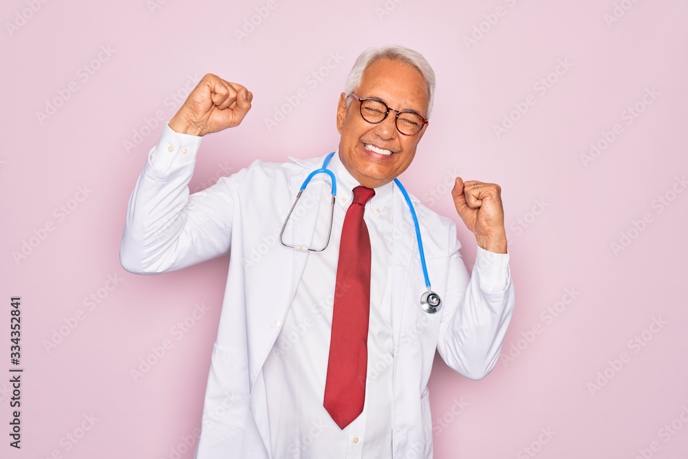 Middle age senior grey-haired doctor man wearing stethoscope and professional medical coat Dancing happy and cheerful, smiling moving casual and confident listening to music Middle age senior grey-haired doctor man wearing stethoscope and professional medical coat Dancing happy and cheerful, smiling moving casual and confident listening to music