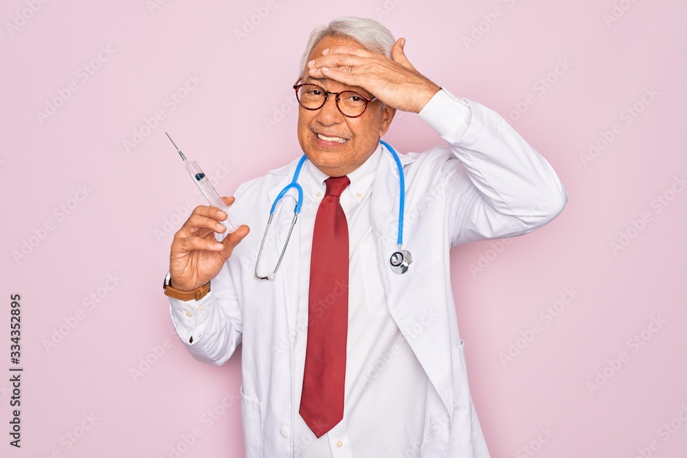Middle age senior grey-haired doctor man holding medicine needle injection over pink background stressed with hand on head, shocked with shame and surprise face, angry and frustrated. Fear and upset Middle age senior grey-haired doctor man holding medicine needle injection over pink background stressed with hand on head, shocked with shame and surprise face, angry and frustrated. Fear and upset