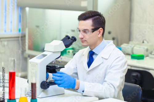 Scientist carries out scientific research looking through microscope in a medical laboratory. COVID-19. COVID Coronavirus
