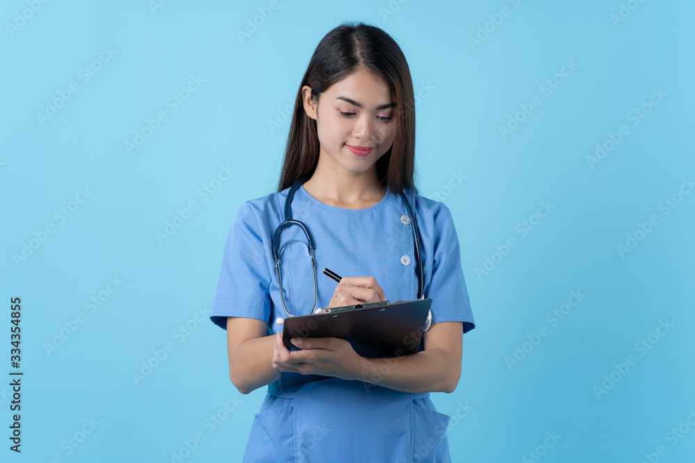 Young woman in nurse uniform smile isolated on light blue background. Young woman in nurse uniform smile isolated on light blue background.