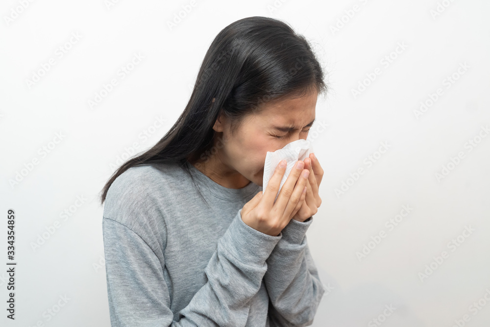 Young asian girl sneezing and use tissue paper close her mouth to protect virus spread isolated on white background. Young asian girl sneezing and use tissue paper close her mouth to protect virus spread isolated on white background.