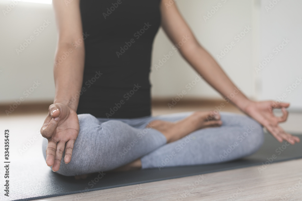 Yoga and meditation lifestyles. close up view of young beautiful woman practicing yoga namaste pose in the living room at home. Yoga and meditation lifestyles. close up view of young beautiful woman practicing yoga namaste pose in the living room at home.