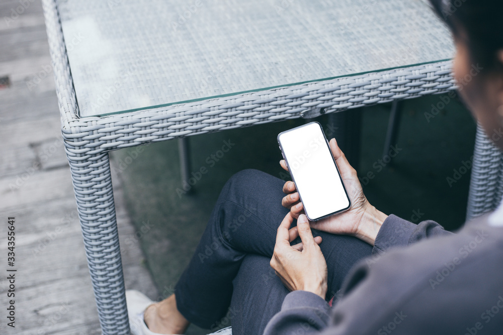 Obraz premium cell phone Mockup image blank white screen.woman hand holding texting using mobile on desk at coffee shop.background empty space for advertise text.people contact marketing business,technology