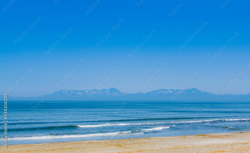 The blue sea is quiet and uninhabited beach. Beyond the rocky mountains he stood firmly high.
