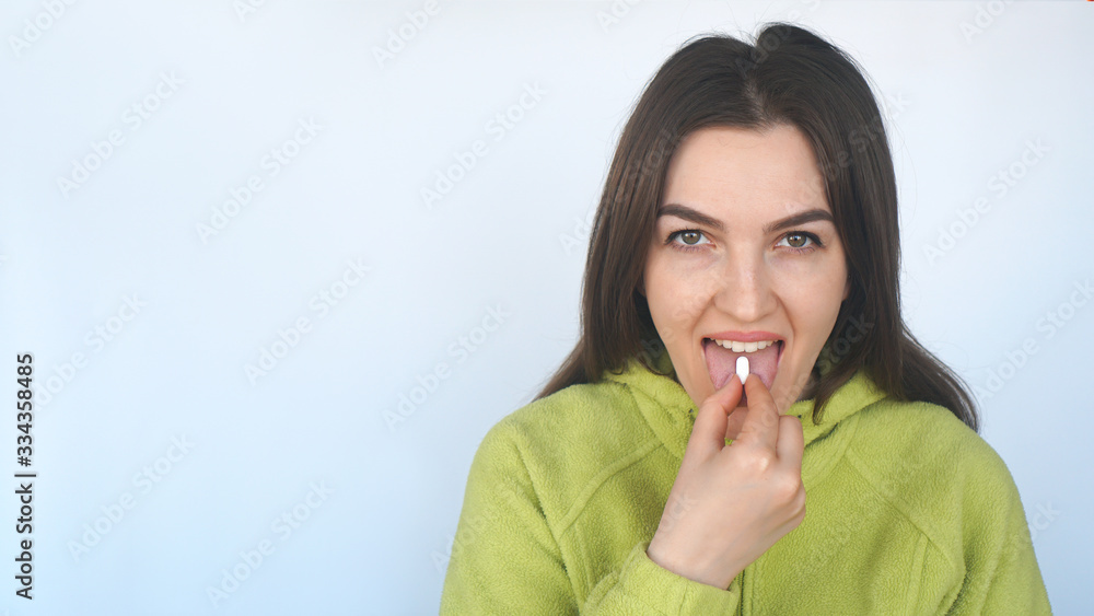 Young woman taking a tablet. Hand with a pill and the mouth. Food Supplements, health care concept. Young woman taking a tablet. Hand with a pill and the mouth. Food Supplements, health care concept.