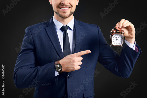 Businessman with alarm cloc...