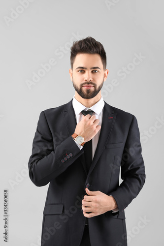 Handsome businessman with healthy hair on light background